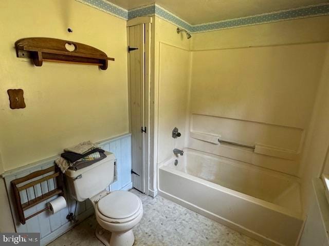 bathroom featuring tub / shower combination, toilet, and tile patterned flooring