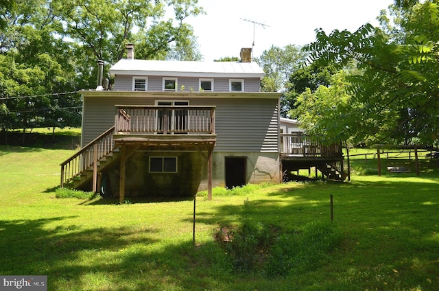 rear view of house with a yard and a wooden deck