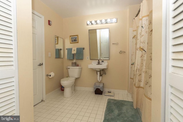 bathroom featuring sink, tile floors, and toilet