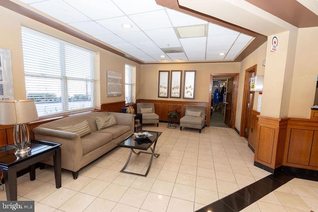 living room featuring a paneled ceiling and light tile floors