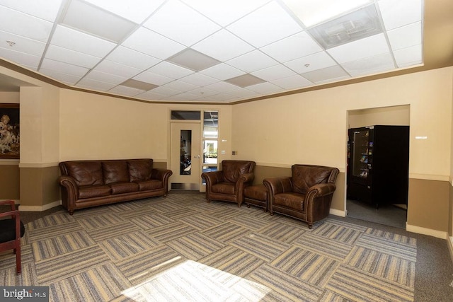 carpeted living room with a paneled ceiling