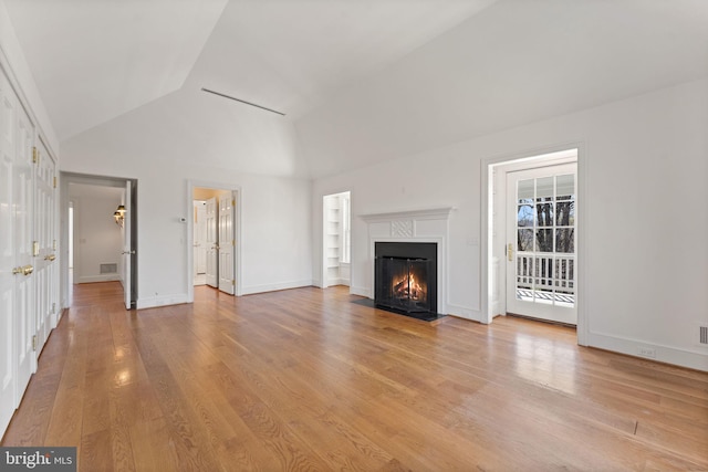 unfurnished living room featuring light hardwood / wood-style flooring and high vaulted ceiling