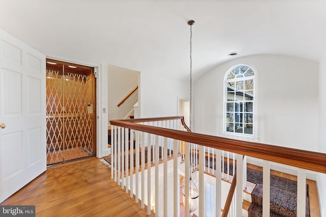 hallway featuring vaulted ceiling and light wood-type flooring