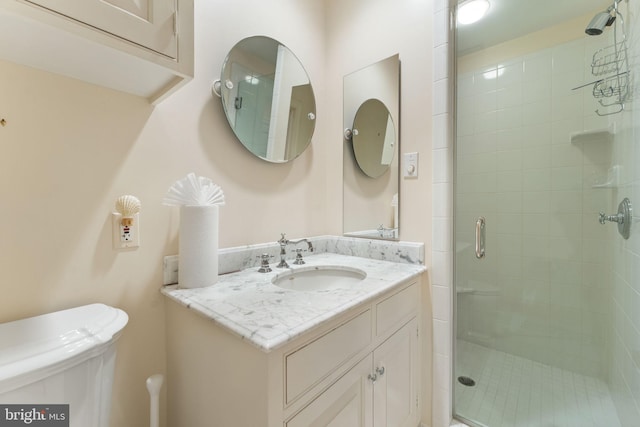 bathroom featuring an enclosed shower, toilet, and large vanity