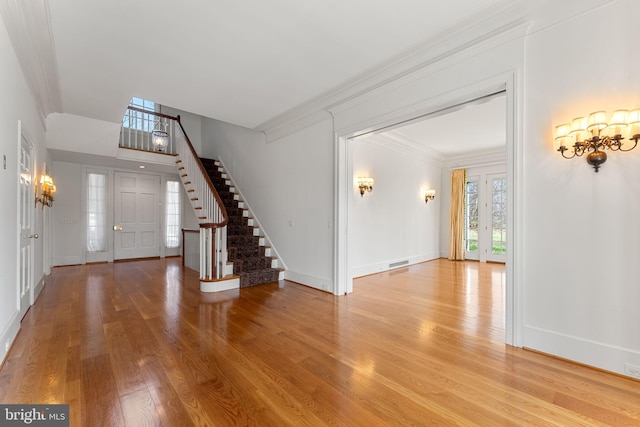 entrance foyer featuring light hardwood / wood-style flooring and crown molding