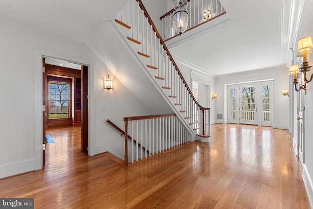 entrance foyer with a notable chandelier, plenty of natural light, and light hardwood / wood-style floors