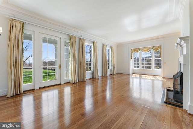 unfurnished living room featuring light hardwood / wood-style flooring and crown molding