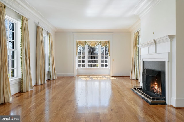 unfurnished living room featuring crown molding, a healthy amount of sunlight, and light wood-type flooring