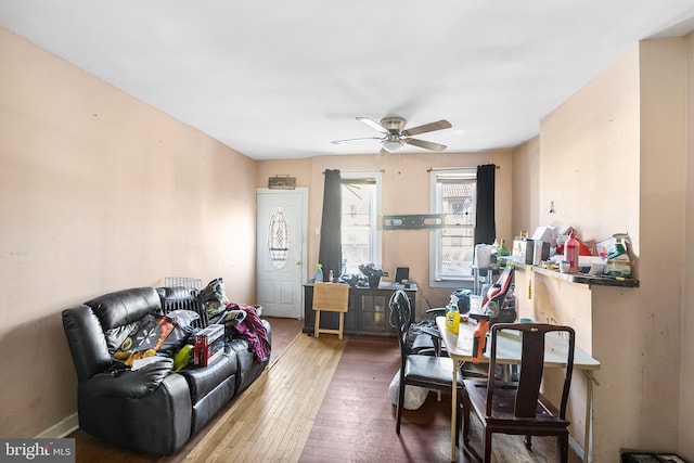 living room with ceiling fan and dark wood-type flooring