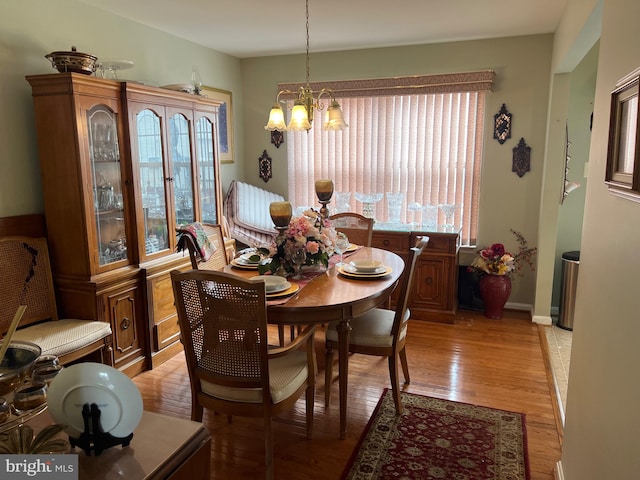 dining area featuring light hardwood / wood-style floors and a chandelier