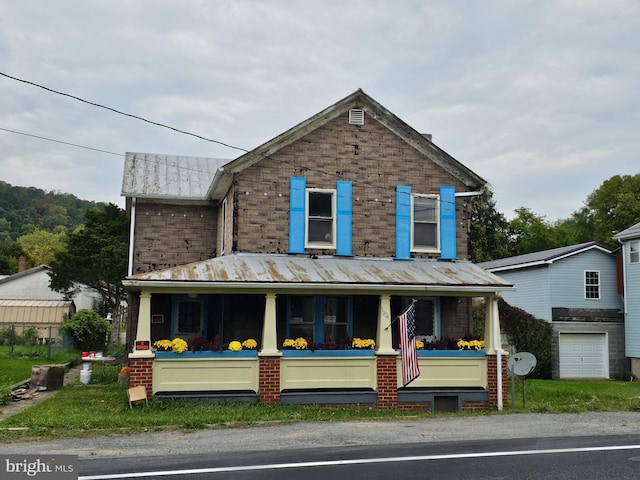 view of front of property featuring covered porch and a garage