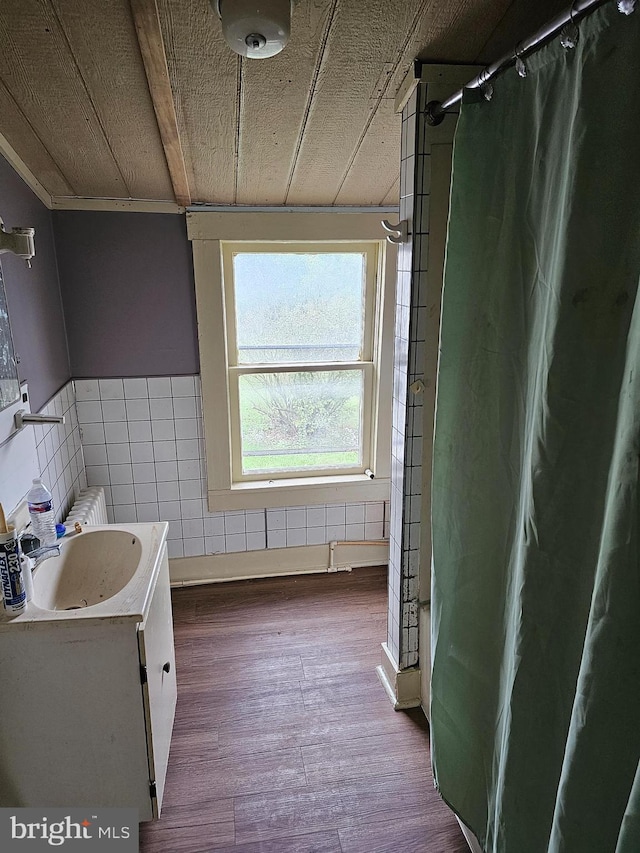 bathroom with tile walls, vanity, and wood-type flooring