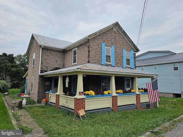 view of front of home with a porch and a front yard