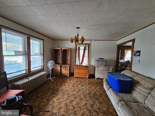 carpeted living room featuring a chandelier, ornamental molding, radiator, and a wall unit AC