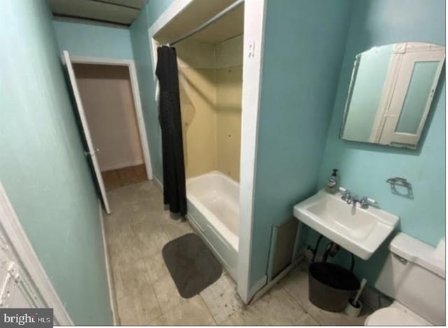 bathroom with toilet, sink, and tile flooring