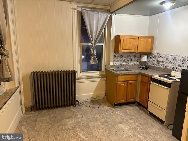 kitchen featuring sink, light tile floors, radiator, backsplash, and white range with electric stovetop