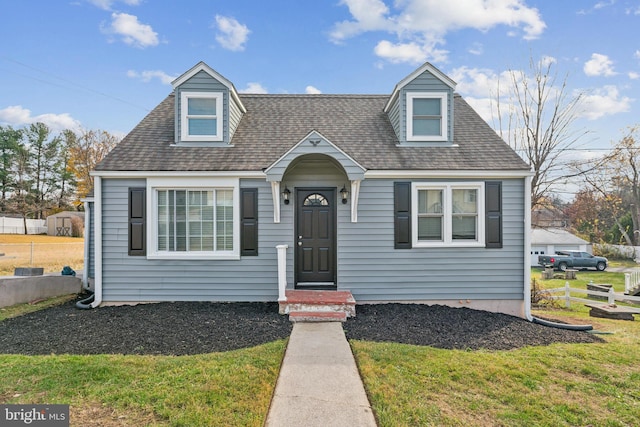 cape cod-style house with a front yard