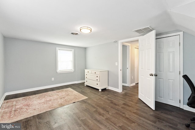 unfurnished bedroom featuring dark hardwood / wood-style floors and vaulted ceiling