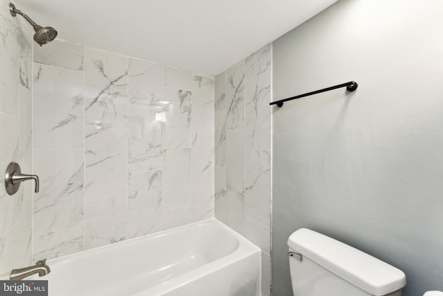 bathroom featuring tiled shower / bath combo and toilet