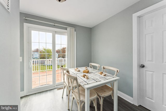 dining space with dark hardwood / wood-style flooring