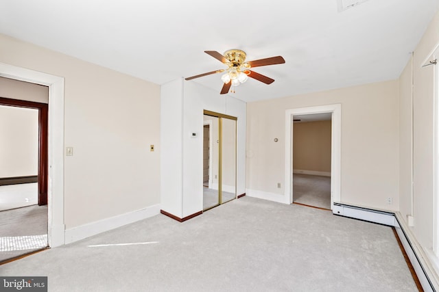 unfurnished bedroom with a closet, light carpet, a baseboard heating unit, and ceiling fan