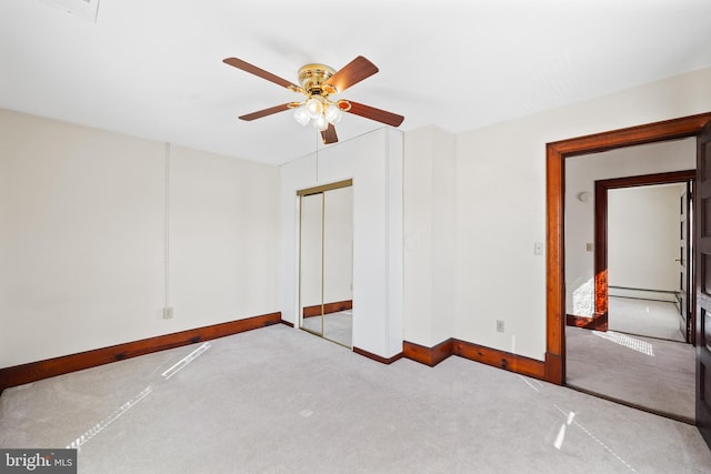 unfurnished bedroom with a closet, baseboard heating, ceiling fan, and light colored carpet