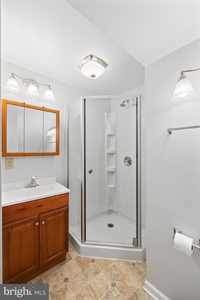 bathroom featuring vanity with extensive cabinet space, tile floors, and a shower with shower door