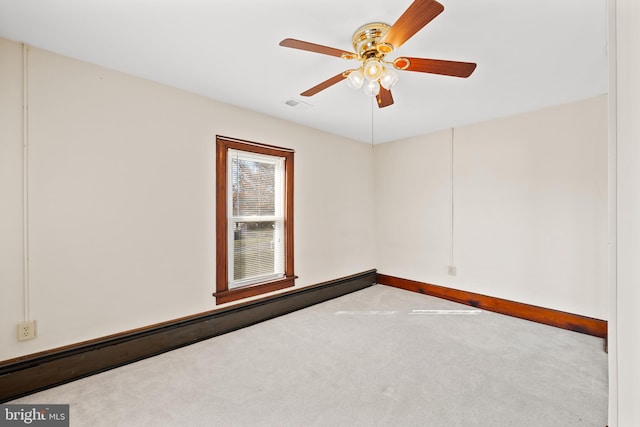 spare room with carpet floors, ceiling fan, and baseboard heating