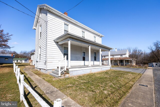 bungalow-style home with covered porch and a front yard