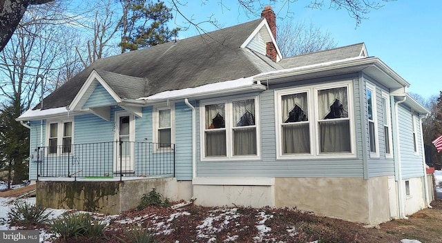 view of side of home featuring covered porch