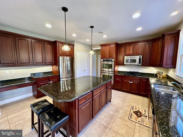 kitchen featuring a kitchen island, pendant lighting, recessed lighting, appliances with stainless steel finishes, and a sink