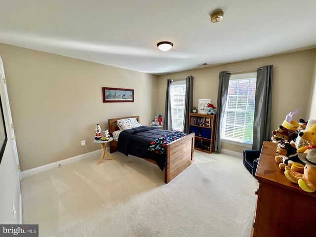 carpeted bedroom featuring visible vents and baseboards