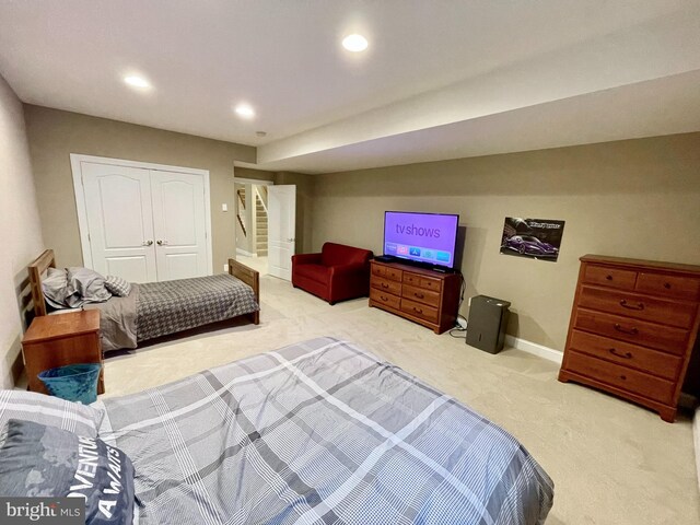 carpeted bedroom featuring a closet, recessed lighting, and baseboards