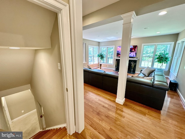 bathroom with a high end fireplace, baseboards, decorative columns, recessed lighting, and wood finished floors