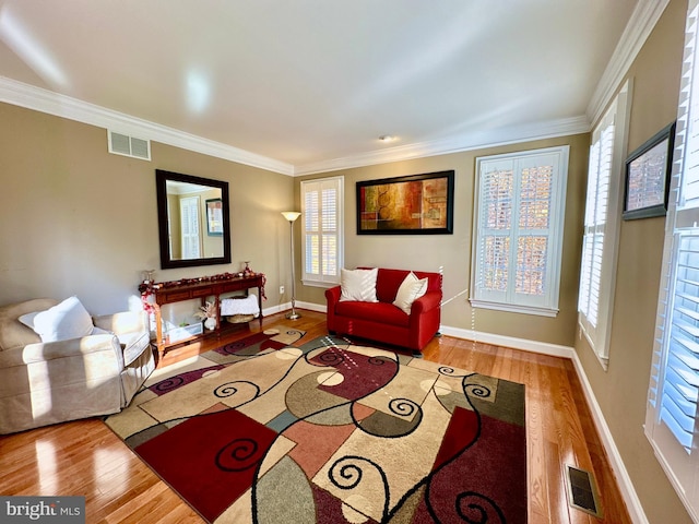 living room featuring visible vents, wood finished floors, and ornamental molding