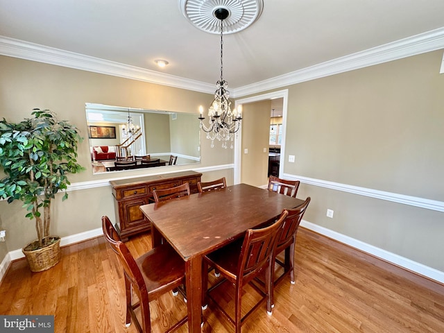 dining room featuring a notable chandelier, baseboards, and light wood-type flooring