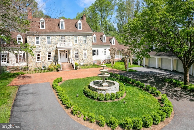 view of front of house with a garage, a front lawn, and an outdoor structure