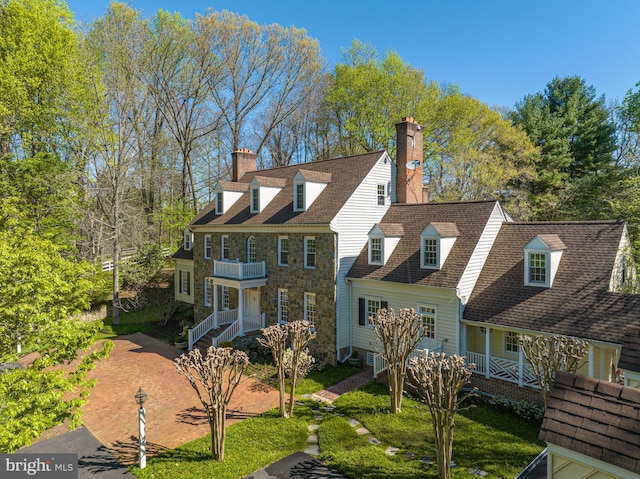 cape cod house with a front yard and a porch