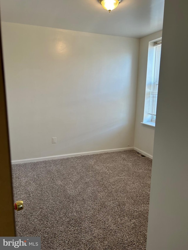 carpeted spare room featuring a wealth of natural light