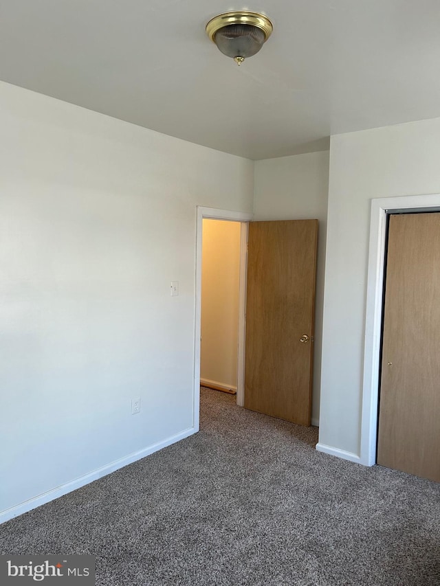 interior space with a closet and dark carpet