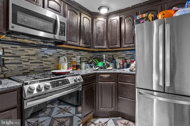 kitchen featuring backsplash, stone countertops, stainless steel appliances, light tile floors, and dark brown cabinetry