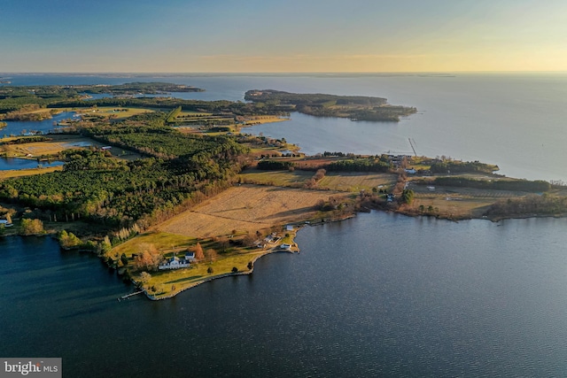 aerial view at dusk featuring a water view