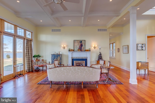 living room with crown molding, beam ceiling, coffered ceiling, light hardwood / wood-style floors, and ornate columns