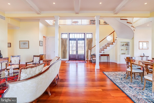 foyer entrance featuring decorative columns, crown molding, and beam ceiling