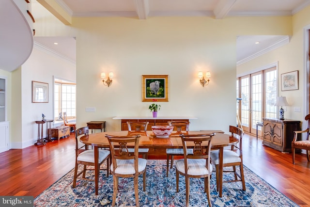 dining area featuring crown molding, wood-type flooring, and beam ceiling