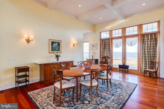 dining space with dark wood-type flooring, french doors, coffered ceiling, a water view, and beam ceiling