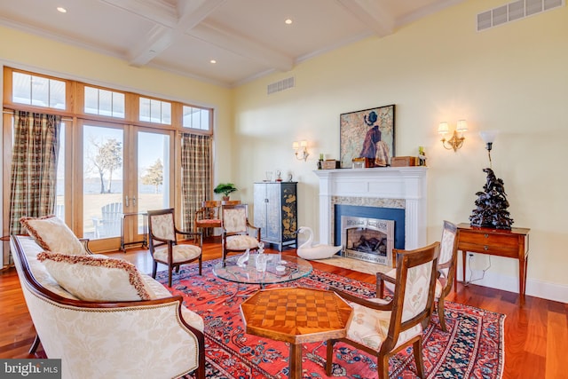 living room featuring crown molding, hardwood / wood-style floors, beam ceiling, and french doors