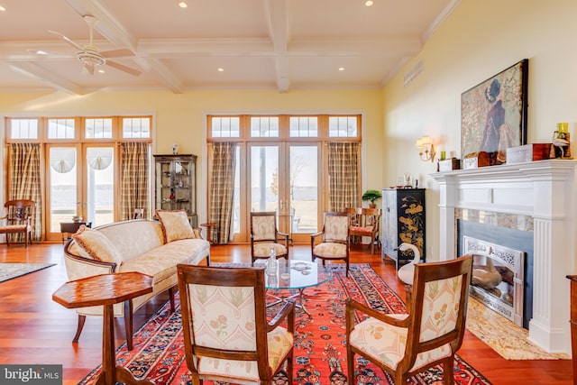 living room featuring hardwood / wood-style floors, a fireplace, beam ceiling, and french doors