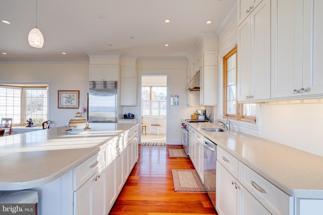 kitchen with high quality appliances, white cabinetry, a kitchen island, and pendant lighting