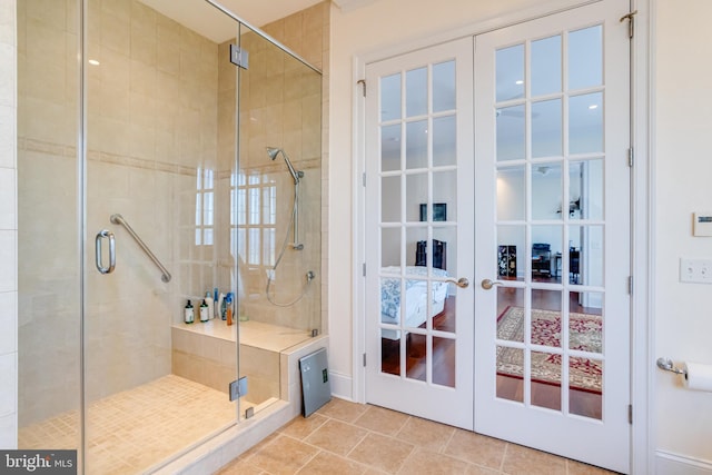 bathroom featuring tile patterned flooring, french doors, and a shower with shower door